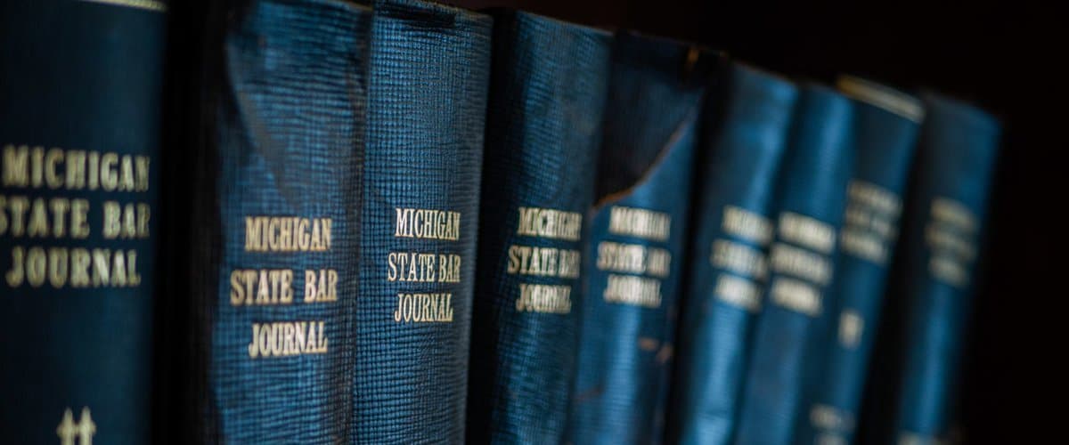 Attorney reviewing a thick legal binder at a warm-lit desk